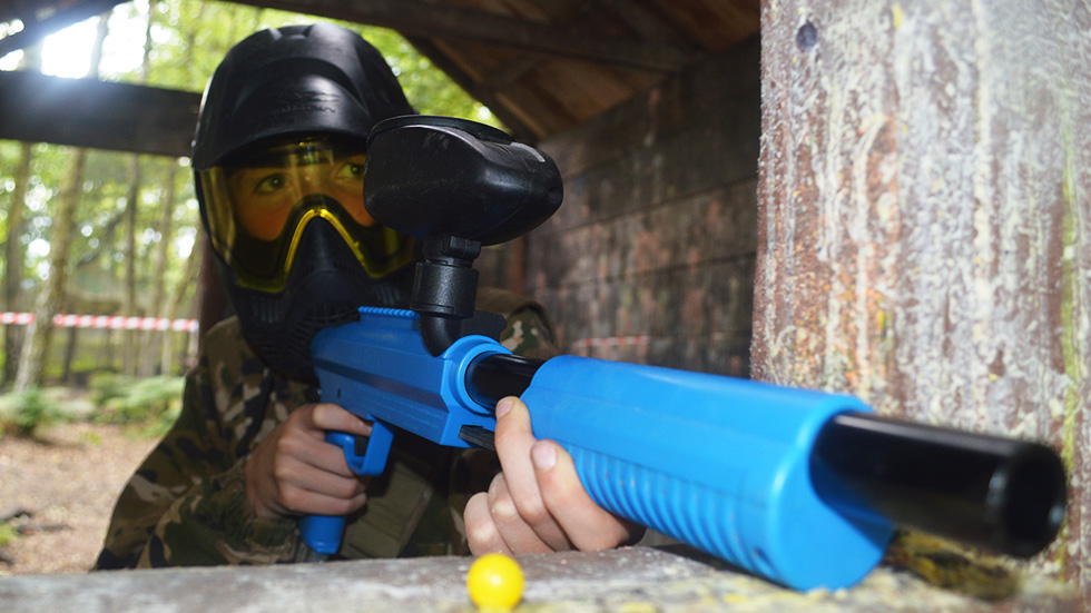young player with mini paintball gun